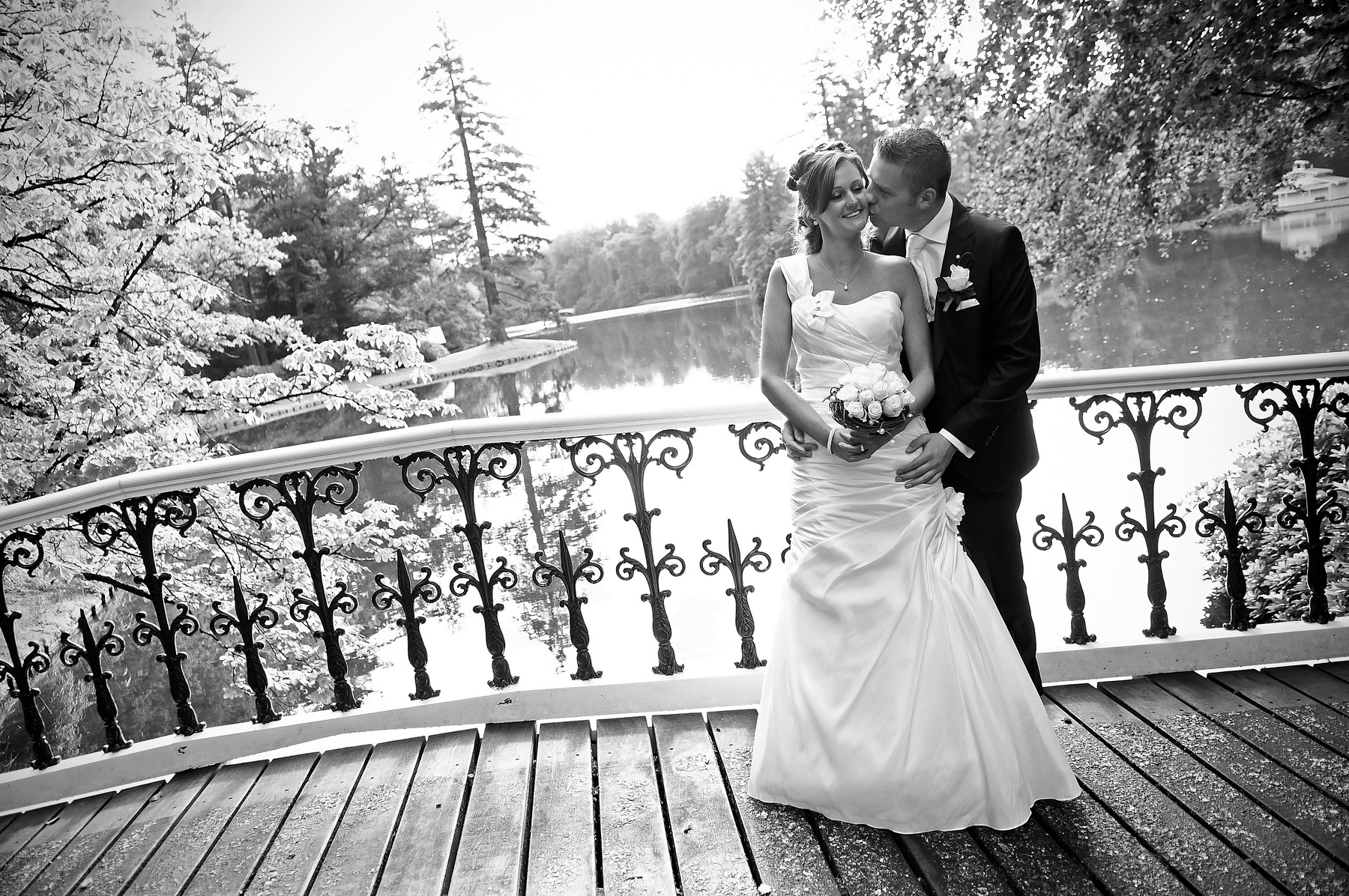 bruidegom kust zijn bruid op een romantische brug gefotografeerd door trouwfotograaf in Almelo