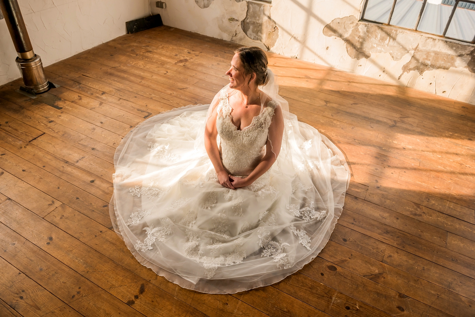 Bruid in witte jurk zit op de grond in De Olde Looierij in Hoogeveen