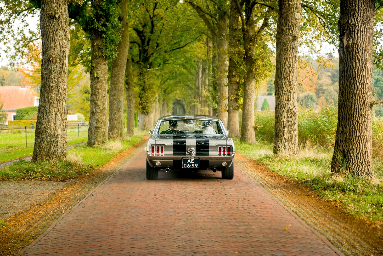 Bruidspaar in een oude klassieke Ford Mustang trouwauto
