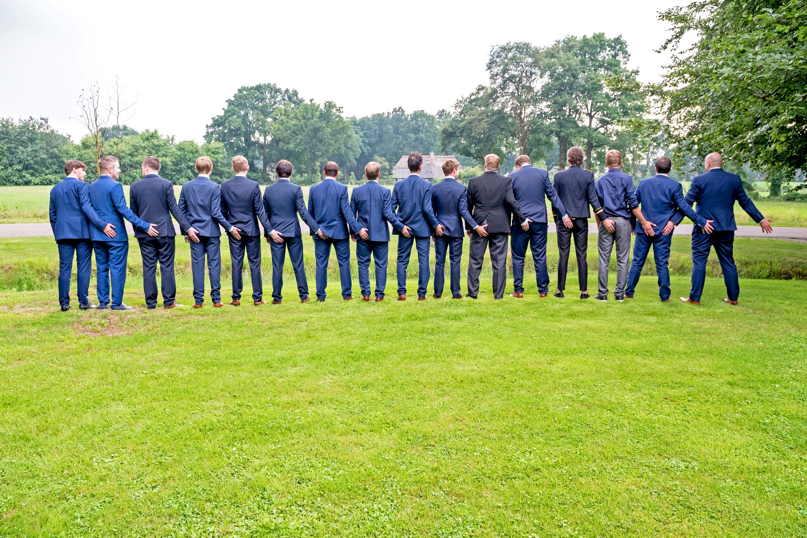Zestien mannen op een rij voor een lollige groepsfoto