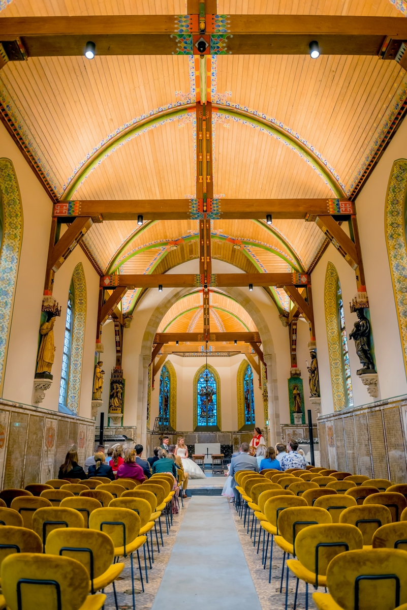 Bruidspaar luistert naar de predikant in de kerk bij Kasteel de Haar in Utrecht